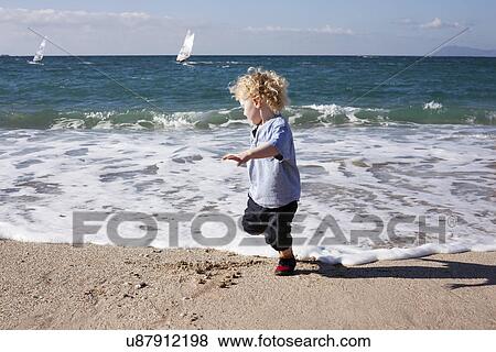 Stock Photo - Boy playing in sea. Fotosearch