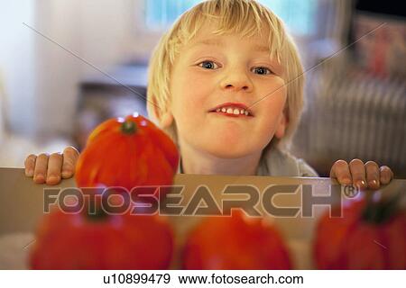 Stock Photo - Boy with homegrown tomatoes. Fotosearch
