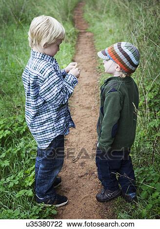 Stock Image - Brothers standing together, outdoors. Fotosearch