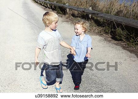 Brothers walking together, holding hands View Large Photo Image Stock Image - Brothers walking together, holding hands. Fotosearch