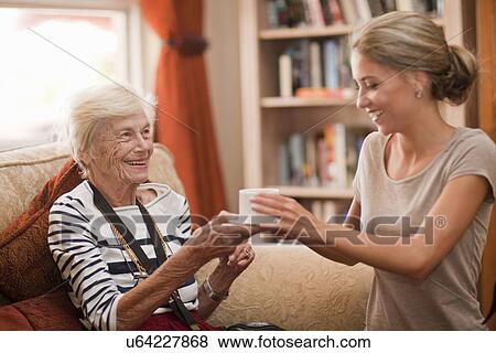 Care assistant handing coffee cup to senior woman View Large Photo Image Stock Photo - Care assistant handing coffee cup to senior woman. Fotosearch