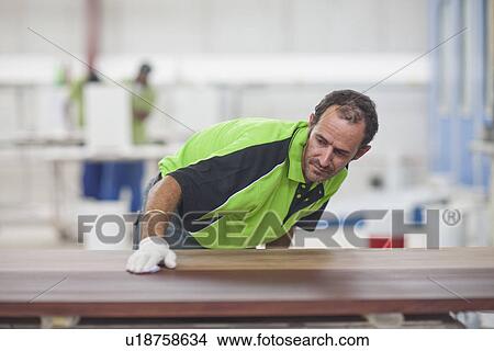 Carpenter checking quality of wood in workshop View Large Photo Image Picture - Carpenter checking quality of wood in workshop. Fotosearch