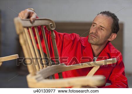 Stock Photo - Carpenter working on chair. Fotosearch