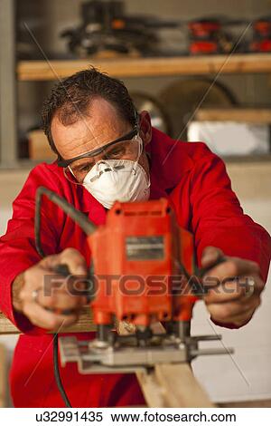 Stock Photography - Carpenter working with power tools. Fotosearch