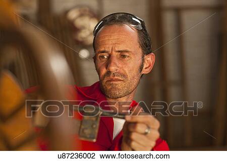Stock Image - Carpenter working with tools. Fotosearch