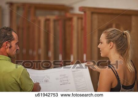 Carpenters looking at house plans View Large Photo Image Stock Image - Carpenters looking at house plans. Fotosearch