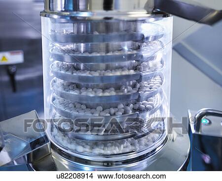 Close up of tablets in tablet pressing machine in pharmaceutical factory View Large Photo Image Picture - Close up of tablets in tablet pressing machine in pharmaceutical factory. Fotosearch