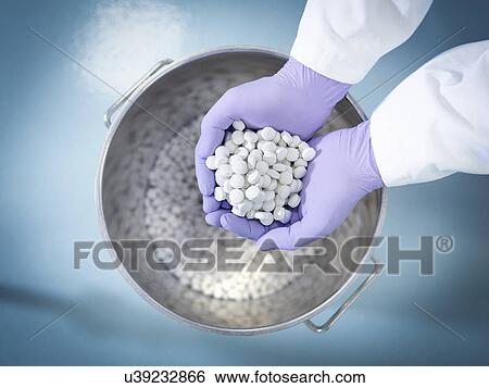 Stock Photograph - Close up of worker inspecting tablets in pharmaceutical factory. Fotosearch