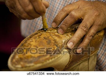 Cobbler applying glue on sole of boot View Large Photo Image Picture - Cobbler applying glue on sole of boot. Fotosearch