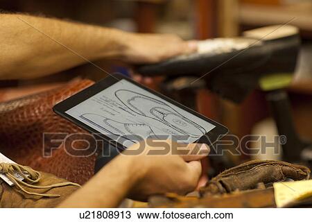 Cobbler holding digital tablet View Large Photo Image Stock Image - Cobbler holding digital tablet. Fotosearch