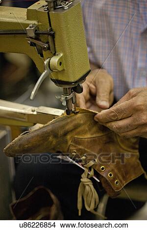 Picture - Cobbler sewing sole of boot. Fotosearch