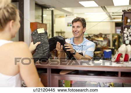 Cobbler showing boots to woman View Large Photo Image Stock Photography - Cobbler showing boots to woman. Fotosearch