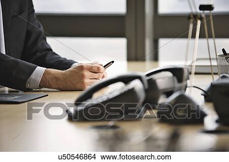 Cropped shot of businessman sitting at boardroom table View Large Photo Image Picture - Cropped shot of businessman sitting at boardroom table. Fotosearch