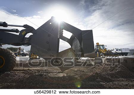 Stock Image - Emergency Response Team digger lifting blocks in training exercise. Fotosearch
