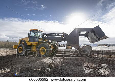 Stock Image - Emergency Response Team digger lifting blocks in training exercise. Fotosearch