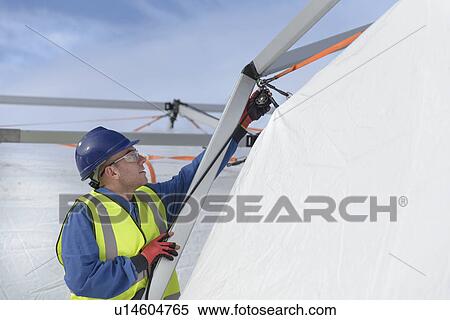 Stock Photography - Emergency Response Team worker erecting tent control centre. Fotosearch