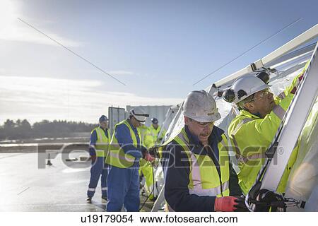 Picture - Emergency Response Team workers erecting tent control centre. Fotosearch