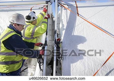 Stock Image - Emergency Response Team workers erecting tent control centre. Fotosearch