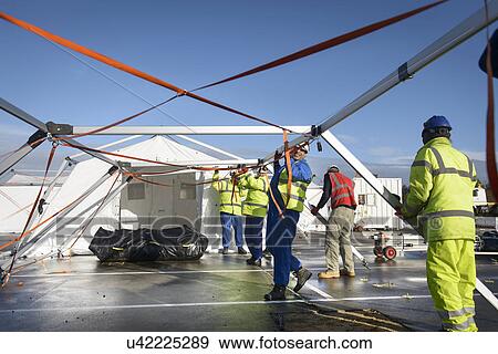Stock Photo - Emergency Response Team workers erecting tent control centre. Fotosearch