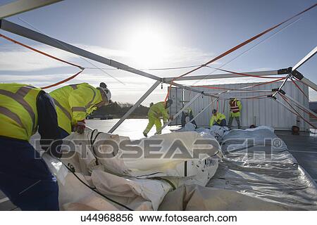 Emergency Response Team workers erecting tent control centre View Large Photo Image Stock Photograph - Emergency Response Team workers erecting tent control centre. Fotosearch