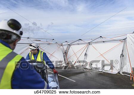 Stock Photography - Emergency Response Team workers erecting tent control centre. Fotosearch
