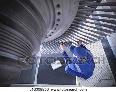 Engineer inspecting steam turbine in repair works View Large Photo Image Stock Image - Engineer inspecting steam turbine in repair works. Fotosearch