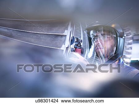 Picture - Engineer repairing steam turbine blade with grinder in workshop. Fotosearch