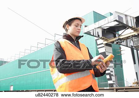 Stock Photo - Female dockworker using monitor. Fotosearch