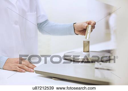 Female pharmacist weighing medicine for prescription View Large Photo Image Stock Photo - Female pharmacist weighing medicine for prescription. Fotosearch