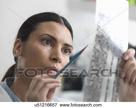Stock Photo - Female scientist examining DNA gel in laboratory for genetic research. Fotosearch