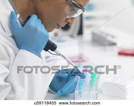 Stock Photography - Female scientist pipetting DNA samples for testing. Fotosearch