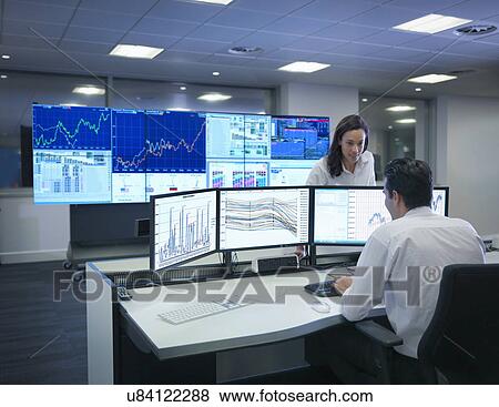 Stock Photo - Financial analysts working with graphs on screens in control room. Fotosearch