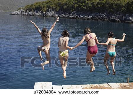 Four girls jumping from pier into the sea View Large Photo Image Picture - Four girls jumping from pier into the sea. Fotosearch