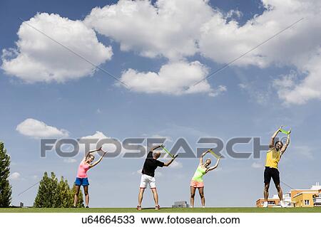Stock Image - Four people training with rubber exercise bands. Fotosearch