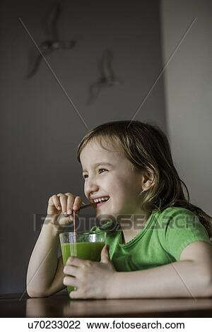 Girl drinking a glass of vegetable juice with straw View Large Photo Image Stock Image - Girl drinking a glass of vegetable juice with straw. Fotosearch