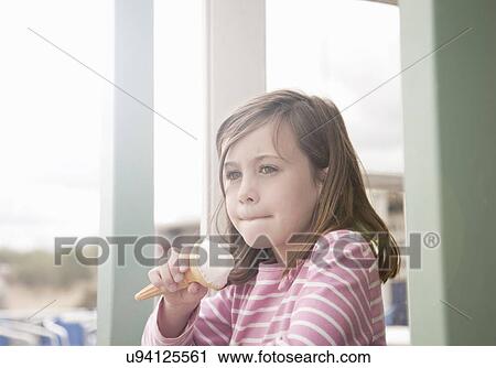 Girl eating ice cream in beach hut porch, Southwold, Sussex, UK View Large Photo Image Stock Image - Girl eating ice cream in beach hut porch, Southwold, Sussex, UK. Fotosearch
