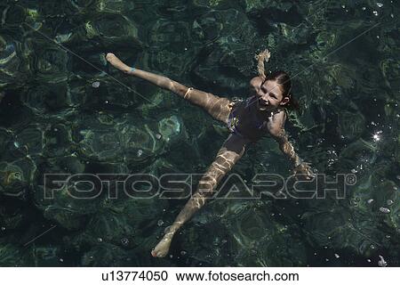 Girl floating with arms and legs outstretched in sea View Large Photo Image Stock Image - Girl floating with arms and legs outstretched in sea. Fotosearch