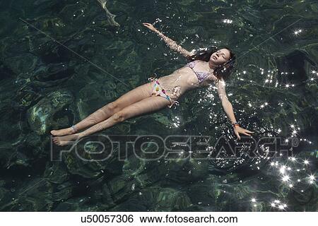 Girl floating with eyes closed in sea View Large Photo Image Stock Photograph - Girl floating with eyes closed in sea. Fotosearch
