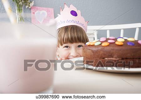 Stock Image - Girl hiding behind cake. Fotosearch