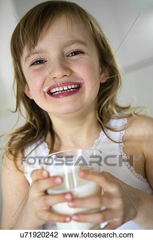 Stock Image - Girl holding a glass of milk. Fotosearch