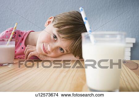 Girl looking at glass of milk View Large Photo Image Picture - Girl looking at glass of milk. Fotosearch