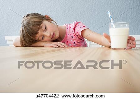 Girl looking at glass of milk View Large Photo Image Stock Image - Girl looking at glass of milk. Fotosearch