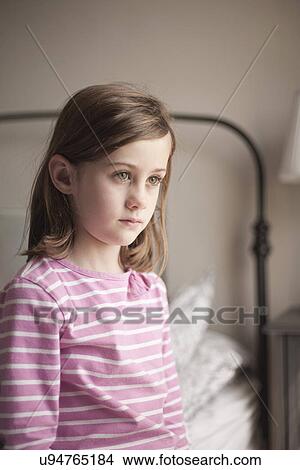 Girl sitting on bed staring View Large Photo Image Picture - Girl sitting on bed staring. Fotosearch