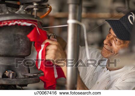 Hat maker cutting and stretching fabric in workshop View Large Photo Image Stock Photograph - Hat maker cutting and stretching fabric in workshop. Fotosearch