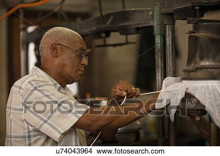 Hat maker tying fabric onto mould in workshop View Large Photo Image Picture - Hat maker tying fabric onto mould in workshop. Fotosearch