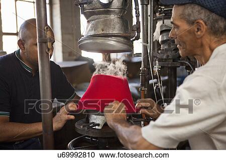 Hat makers pulling fabric onto mould in workshop View Large Photo Image Stock Image - Hat makers pulling fabric onto mould in workshop. Fotosearch