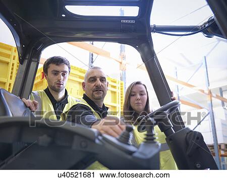 Instructor showing apprentices controls of forklift truck View Large Photo Image Stock Image - Instructor showing apprentices controls of forklift truck. Fotosearch