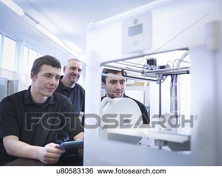 Stock Photograph - Instructor with apprentices and 3D printing machine. Fotosearch