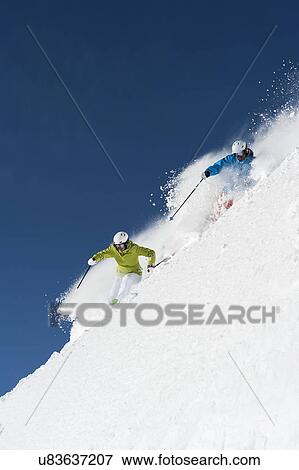 Stock Photo - Male and female skiers racing downhill, Obergurgl, Austria. Fotosearch