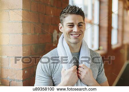 Man in gym with towel around neck View Large Photo Image Stock Image - Man in gym with towel around neck. Fotosearch